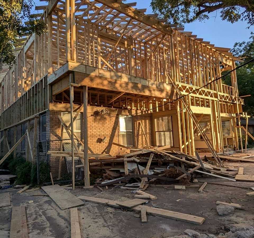Two story wall framing going up over an existing brick house, a Monarch job